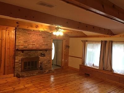 Huge living room with wood floors. Wood burning fireplace