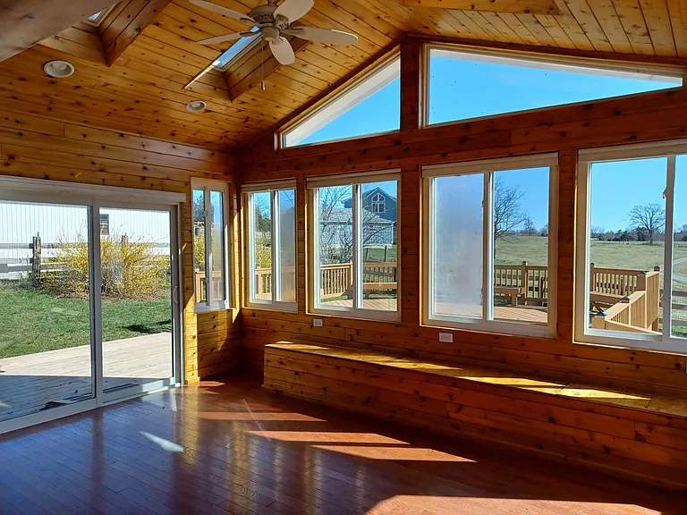 sunroom and skylights with deck beyond