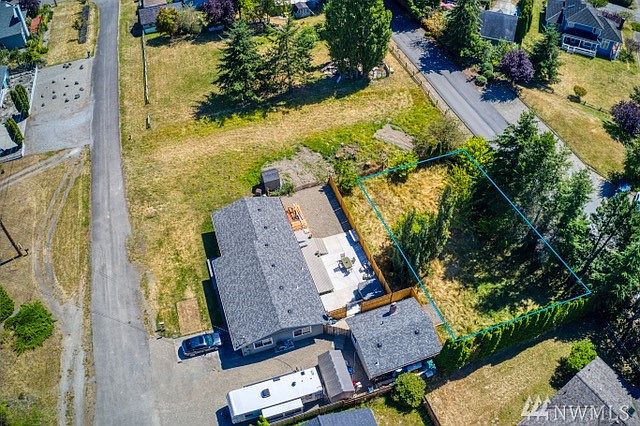 Overhead view of the lot seen outlined in blue on right.  The area above the lot is undeveloped Hendricks Street.  The paved road on left is 1st Street.  The paved road on right is Grant Street leading into the Forest Park Condo community.