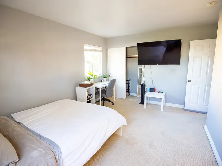 Fully furnished room with queen bed, mattress, desk, chair, tower fan, shelving for organization, 50 inch smart TV, etc