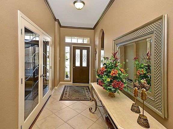 Lovely long entrance into your beautiful home with crown molding and tile.