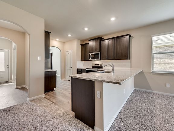 The kitchen is open to the living room and dining room in the Maple plan.