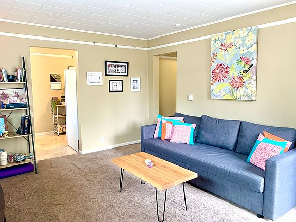 Living room opens to kitchen on left and hallway to right.