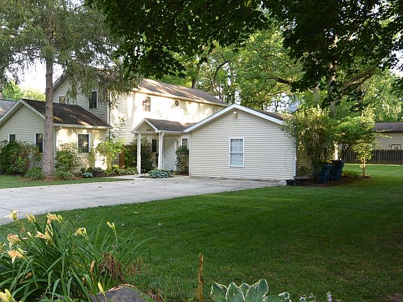 Street view of front of house and 4 car concrete driveway.