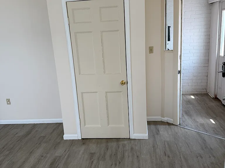 View of open front door and building vestibule area. Also visible is coat closet.