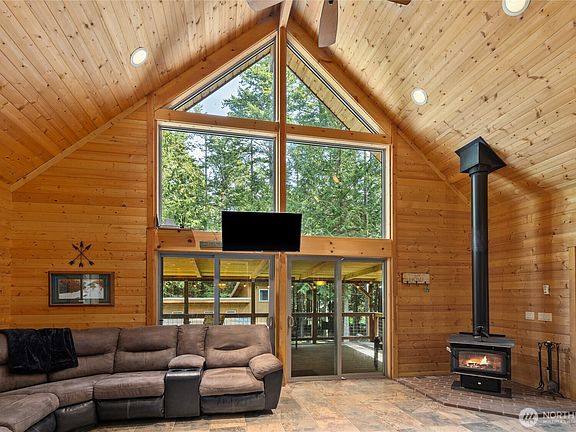 Gorgeous great room with toasty free standing wood stove, floor to ceiling windows.>