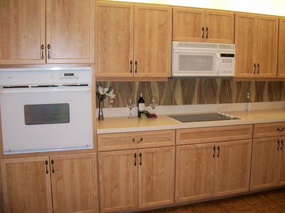 Kitchen features loads of cabinets, wall oven and cooktop