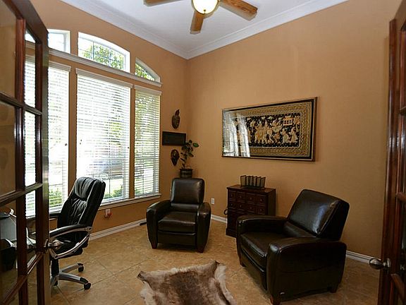 French doors open to the Executive style study accented by double crown molding and a ceiling fan with light fixture.