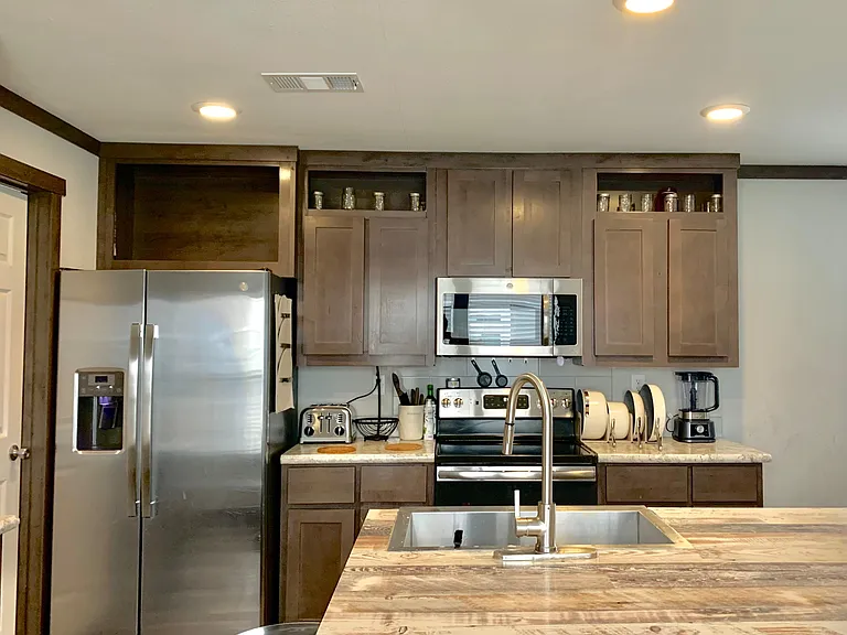 Well-equipped kitchen with stainless steel appliances, ample cabinet storage, and a center island with sink and prep space.