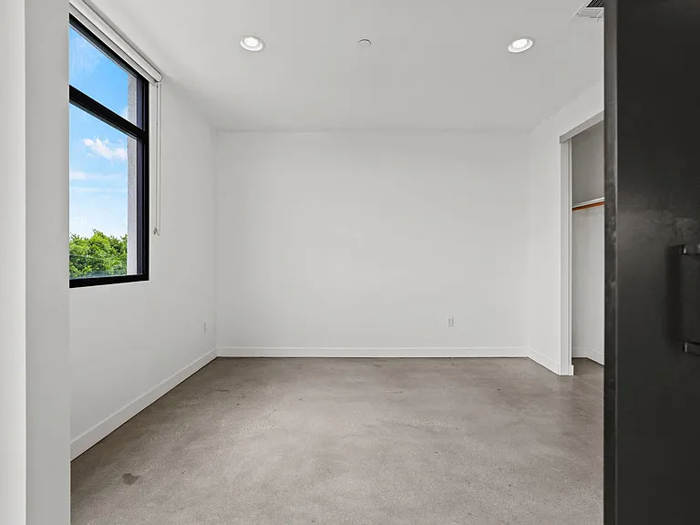Bedroom with Concrete Flooring, Recessed Lighting, Large Windows