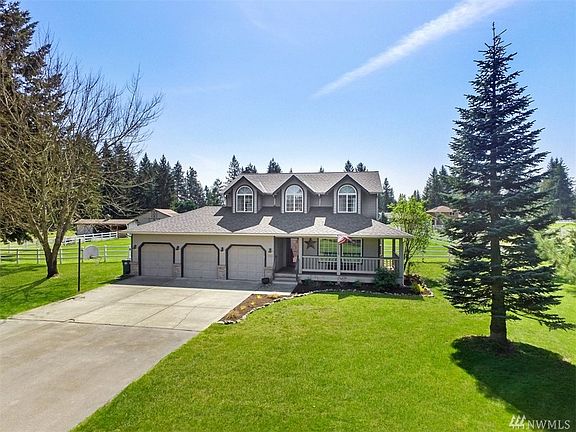 Front of house showing well-manicured yard & 3-bay garage