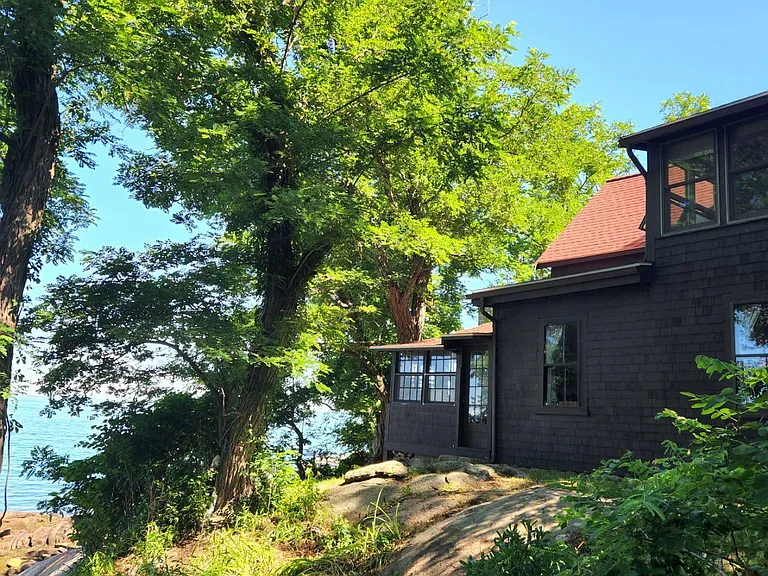 The side of the house showing the front porch where the queen bedroom is on the first level