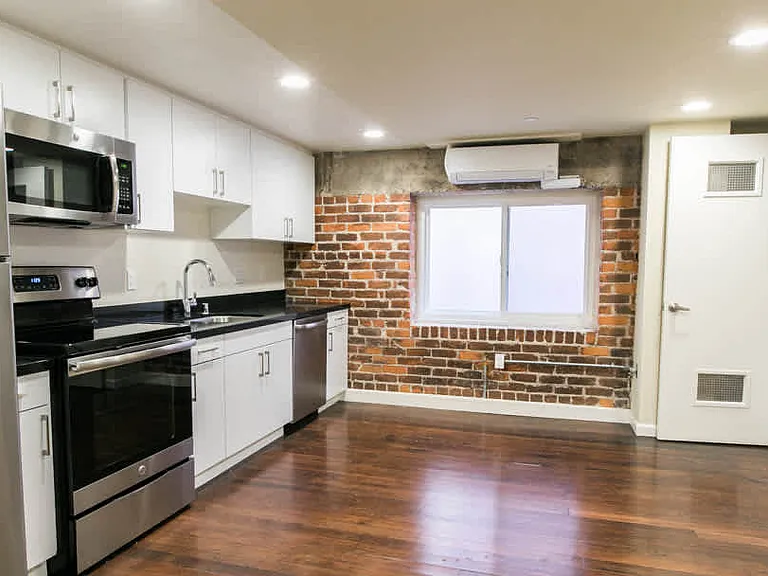 Kitchen with Stainless Steel Appliances and Living Area with Resurfaced Wood Floors