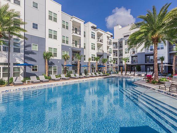 Resort-style swimming pool surrounded by lounge chairs
