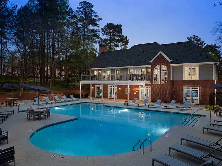 View of the clubhouse at twilight with the pool and sundeck