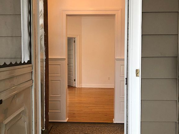 Entrance from porch into unit that includes foyer.