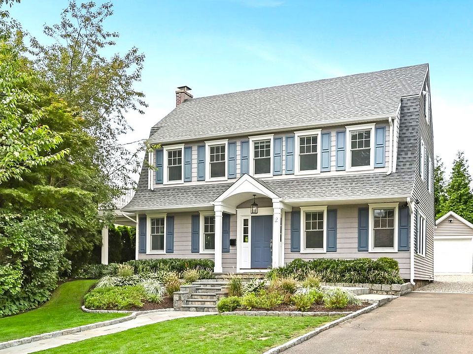 A charming pebble driveway leads to a one-car garage