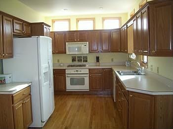 Huge kitchen with loads of cabinets and countertops, windows above the cabinets for an extra bright 