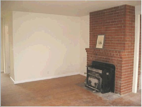 Brick fireplace in living room with hardwood floors