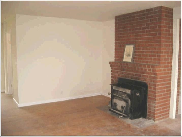 Brick fireplace in living room with hardwood floors