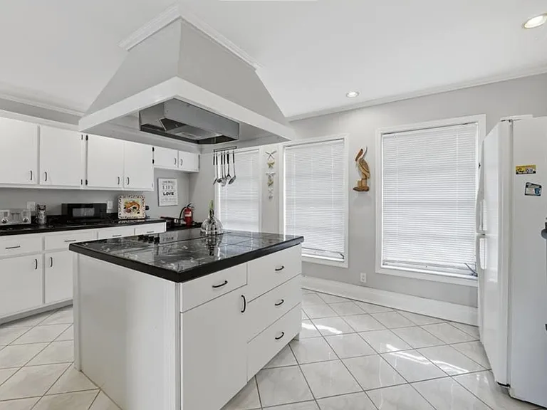 Spacious kitchen with a large center island, ample cabinet storage, and full-size appliances, plus two big windows for natura