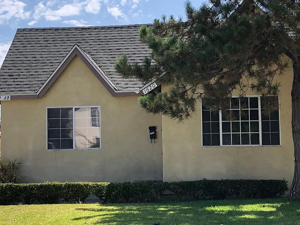 A nice lawn and big shady tree adorn the front of the house.