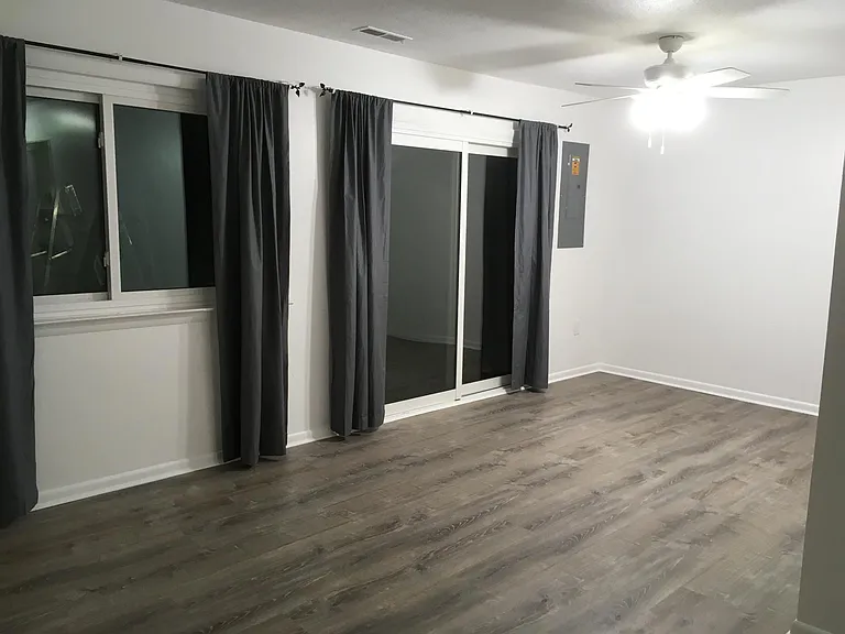 Living room. Sliding glass door goes out to the patio. New ceiling fan. You may use the curtains.