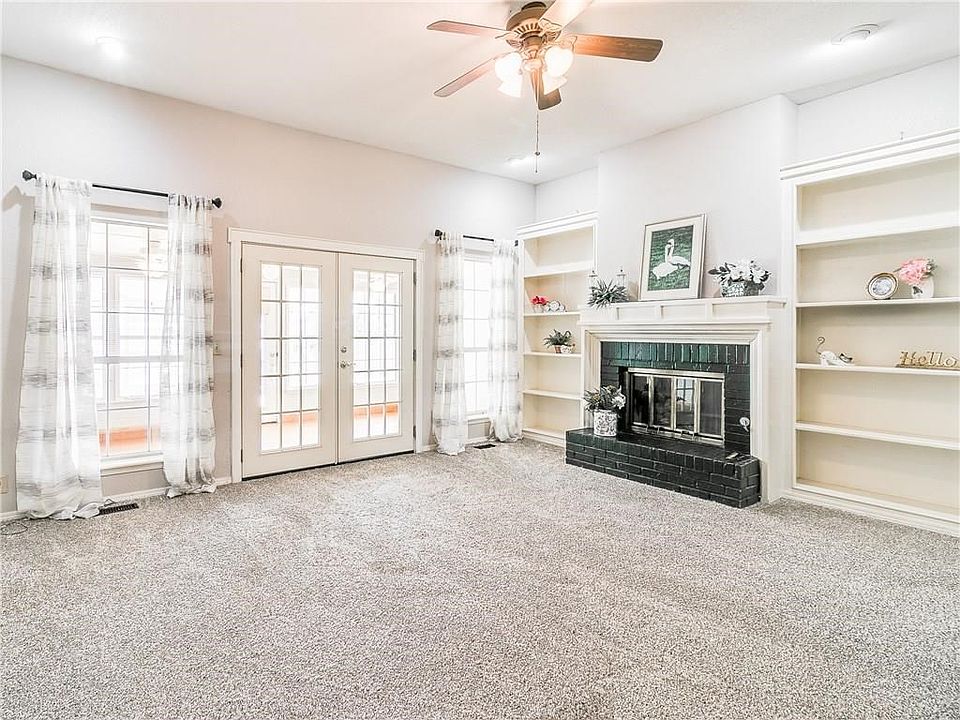 Very spacious living room with built-in shelves, and ceiling fan.