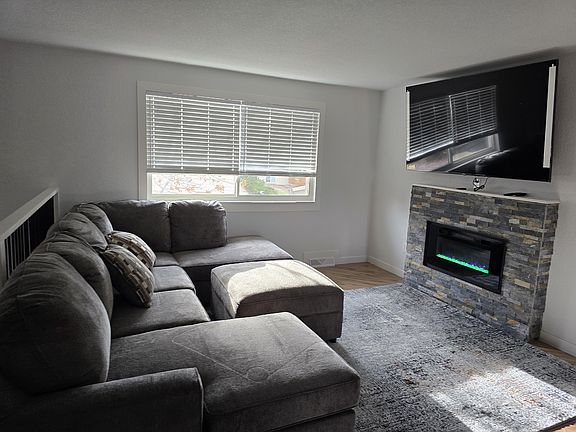 Beautiful living room with 75 Inch adjustable smart TV with electronic fireplace.