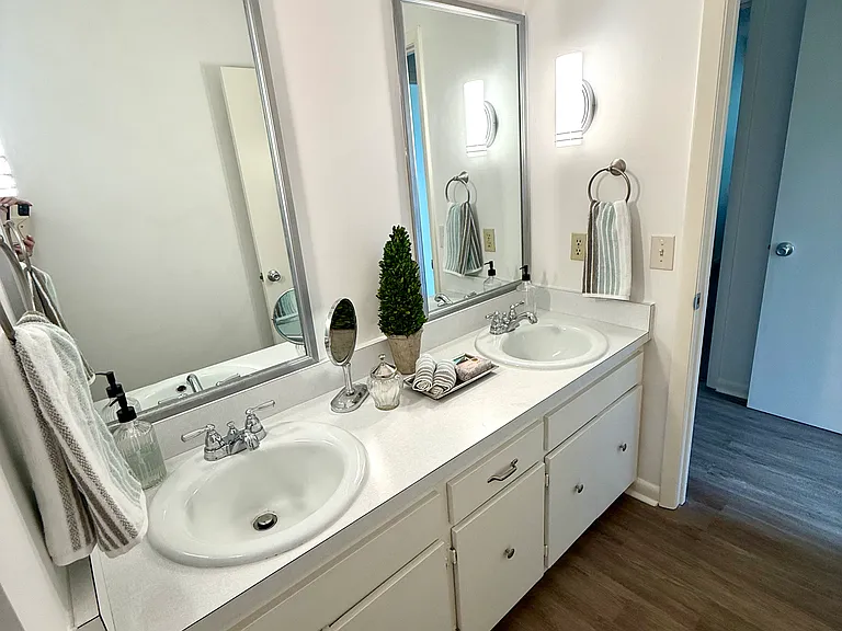 This is a close up view of just the vanities showing the double sinks, double light and double mirrors for each person to have their own space for getting ready for their day.