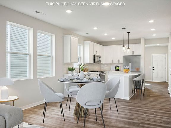 Standing in the gathering and dining room areas looking into the beautiful kitchen