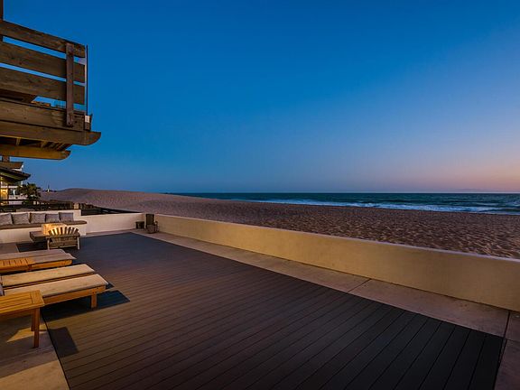 Front deck with firepit and chaise loungers on beach