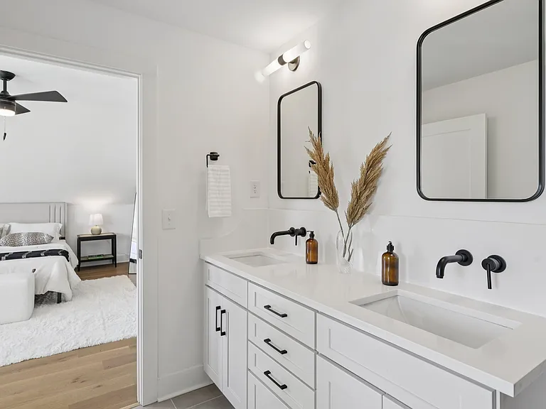 Primary bathroom with double vanities, custom cabinetry, and modern finishes.