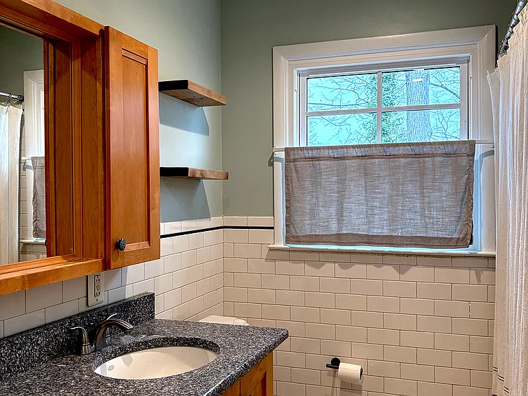 Full bath on third floor with 2 sinks and tub with shower.