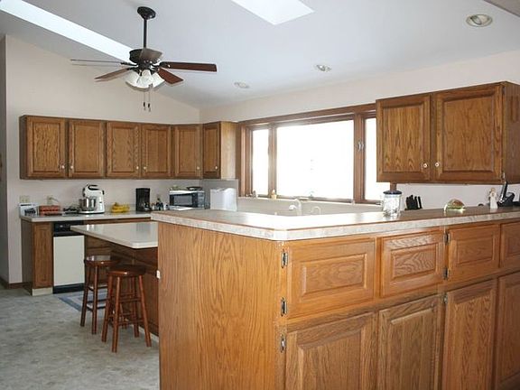 View from the dining room into the kitchen shows the amazing amount of counter space and storage. Not shown in this picture is a full wall of pantry storage as well. The skylights and vaulted ceilings make this space cheerful and bright!