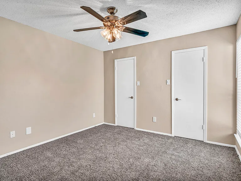 Bedroom with natural light, ceiling fan, and spacious closet.