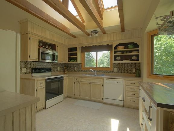Stunning kitchen! Modern backsplash, refinished cabinetry. It's a standout with it's bright skylights accented by elegant wood beams.