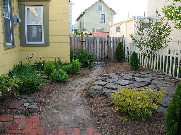 Landscaped side yard, leading to fully fenced backyard