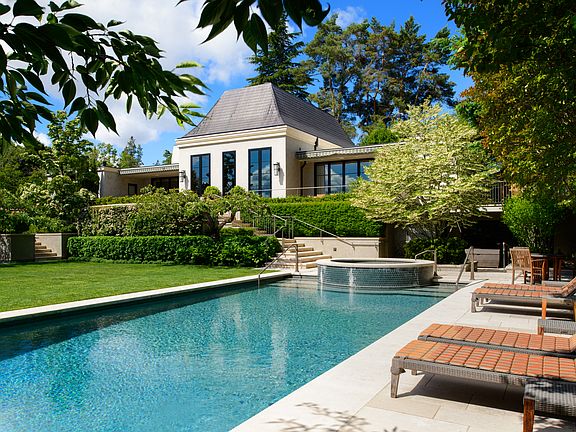 The pool and spa are secluded and surrounded by tall trees, while retaining views of the garden and the lake.