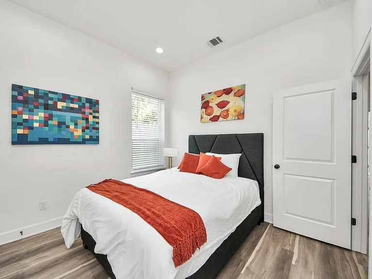 Well-appointed bedroom with a comfortable bed, bedside lighting, and a window with blinds for adjustable privacy.