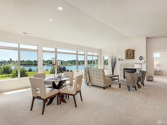 Gorgeous open concept living. The wall of windows brings in the water, the mountains. Vaulted ceilings make it feel even more spacious.