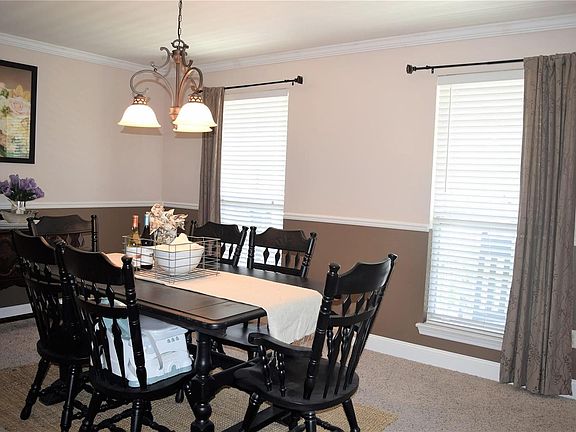 Formal dining room with chair rail and crown molding. This owner has added deeper baseboards and oil-rubbed bronze light fixture