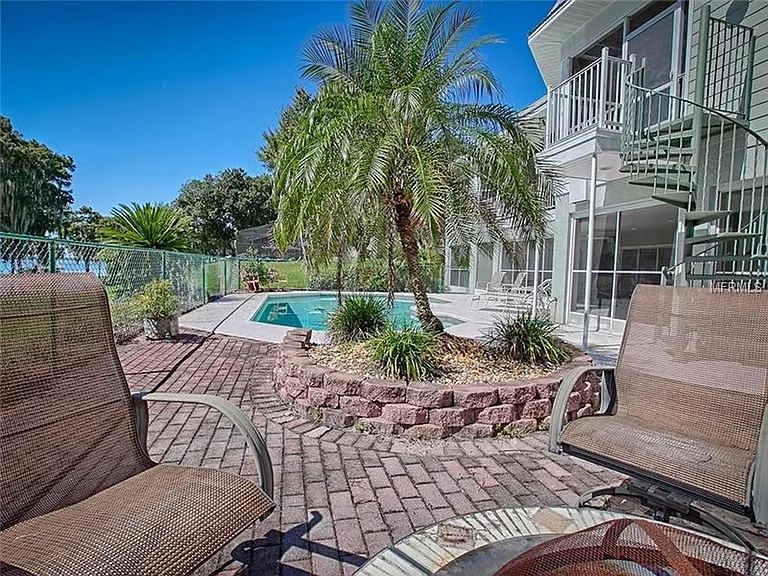 This is the pool and pool deck with its screened patio and spiral staircase to the upper main screened in porch.