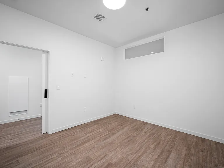 Chic empty room featuring sleek hardwood floors and pristine white walls, showcasing modern and minimalist design. Chic empty room featuring sleek hardwood floors and pristine white walls, showcasing modern and minimalist design.