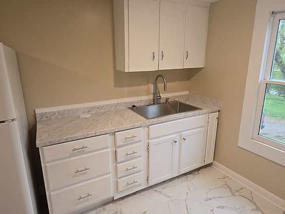 The Kitchen sink and cabinet side, with stove on the right side not showing in this photo.