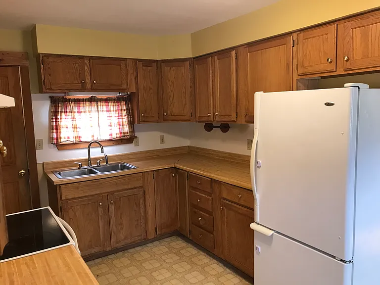 Kitchen with back door to pantry shelves and back staircase.