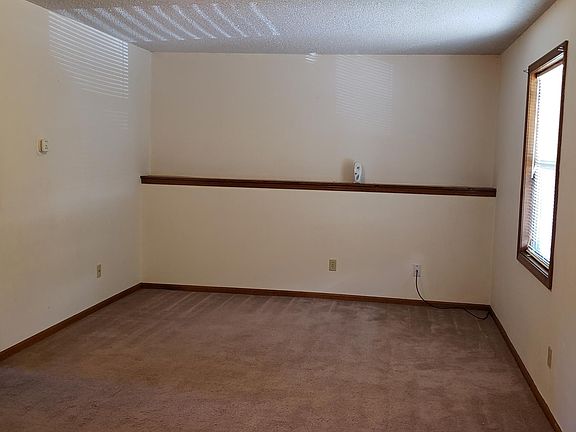Living room with picture or knick knack shelf along the wall.
