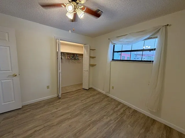 Spare bedroom with window overlooking pool.