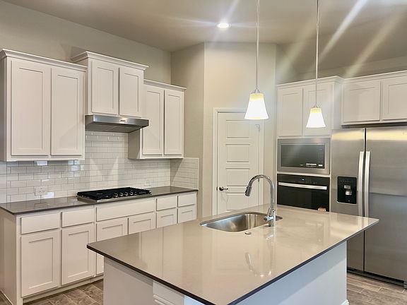 open Kitchen with Refrigerator, Microwave and oven. Quartz island