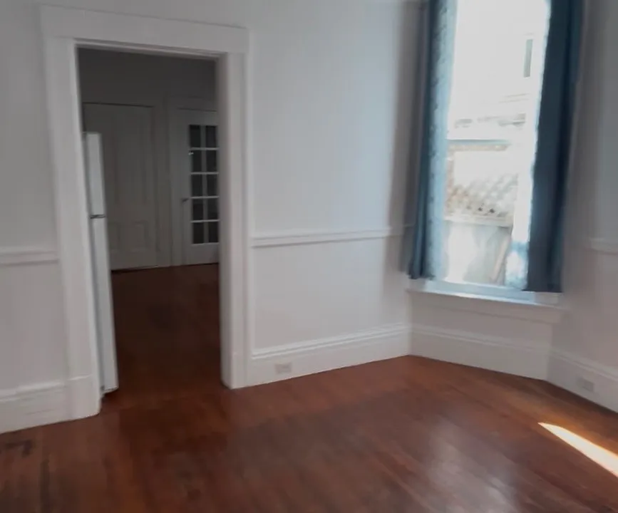 View from main room toward kitchen, bonus space and rear door to garden.
